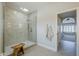 Modern bathroom with a glass-enclosed shower, tiled walls, skylight, and a view into another room at 8100 E Camelback Rd # 143, Scottsdale, AZ 85251