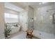 Bright bathroom featuring a soaking tub next to a window and a separate shower with a glass door at 8100 E Camelback Rd # 143, Scottsdale, AZ 85251