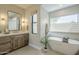 Bathroom showcasing a vanity with a mirror, a soaking tub, and natural light from two windows at 8100 E Camelback Rd # 143, Scottsdale, AZ 85251