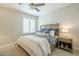 Bedroom showcasing a bed with blue and white bedding, a ceiling fan, and natural light from a shuttered window at 8100 E Camelback Rd # 143, Scottsdale, AZ 85251