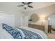 Bright bedroom showing a bed with patterned bedding, a ceiling fan, and a dresser with decor at 8100 E Camelback Rd # 143, Scottsdale, AZ 85251