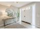 Bright foyer with large circular mirror, console table, and view of the staircase at 8100 E Camelback Rd # 143, Scottsdale, AZ 85251