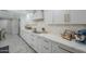 Bright, white kitchen featuring modern appliances and marble countertops with gold hardware and herringbone backsplash at 8100 E Camelback Rd # 143, Scottsdale, AZ 85251