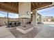 Outdoor covered dining area with a fireplace and lounge chairs by the pool at 8100 E Camelback Rd # 143, Scottsdale, AZ 85251