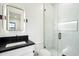 Modern bathroom featuring a glass-enclosed shower with marble tile and a sleek black countertop at 8147 E Redberry --, Mesa, AZ 85207