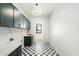 Well-lit laundry room with custom cabinetry, marble countertops, and black and white checkered flooring at 8147 E Redberry --, Mesa, AZ 85207