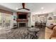 Cozy living room featuring a stone fireplace, ceiling fan, and access to the outdoor space at 9735 N 94Th Pl # 110, Scottsdale, AZ 85258