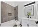 Modern bathroom with gray tile shower, new fixtures, a white vanity with marble countertop, and decorative mirror at 10631 N 15Th Way # 4, Phoenix, AZ 85020