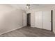 Well-lit bedroom featuring wood-look floors, ceiling fan, and a closet with sliding doors at 1182 E Harrison St, Gilbert, AZ 85295