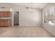 Bright dining space with tile floors, a modern chandelier, and lots of natural light from a large window at 1182 E Harrison St, Gilbert, AZ 85295