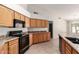 Bright kitchen features ample cabinetry, black appliances, granite countertops, and a center island with sink at 1182 E Harrison St, Gilbert, AZ 85295
