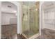 Modern bathroom with a walk-in tiled shower and a view into the bedroom and walk-in closet at 12056 W Melinda Ln, Sun City, AZ 85373