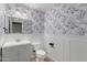 Stylish half bathroom featuring modern wallpaper, vanity, toilet, and new fixtures at 12056 W Melinda Ln, Sun City, AZ 85373