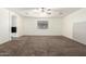 Spacious carpeted bedroom with a ceiling fan, neutral paint, and a window for natural light at 12056 W Melinda Ln, Sun City, AZ 85373