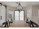 Dining area featuring an elegant chandelier, sliding glass doors and tile flooring at 12056 W Melinda Ln, Sun City, AZ 85373