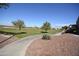 Landscaped front yard featuring desert landscaping with a view of the green space and surrounding natural desert at 12056 W Melinda Ln, Sun City, AZ 85373