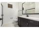Modern bathroom featuring dark cabinets, white countertops, and a large framed mirror at 1331 E La Mirada Dr, Phoenix, AZ 85042