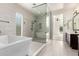 Bright bathroom featuring a freestanding tub, a large glass shower, and a view into the bedroom at 1331 E La Mirada Dr, Phoenix, AZ 85042