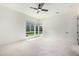 Bright bedroom with plush carpet, modern ceiling fan, and many windows overlooking the manicured backyard at 1331 E La Mirada Dr, Phoenix, AZ 85042