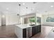 Kitchen featuring island with stainless appliances, pendant lights, and open access to living area at 1331 E La Mirada Dr, Phoenix, AZ 85042