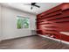Bright home office features dark wood floors, floating desk, and red wall with shelving at 1331 E La Mirada Dr, Phoenix, AZ 85042