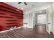 Home office features dark wood floors and floating shelves along a red accent wall at 1331 E La Mirada Dr, Phoenix, AZ 85042