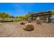 Play area featuring rocks and tree stumps, adjacent to shaded community outdoor picnic pavilion at 1331 E La Mirada Dr, Phoenix, AZ 85042