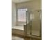 Bathroom featuring a tub with glass block window and a glass-enclosed shower at 13542 W Port Au Prince Ln, Surprise, AZ 85379