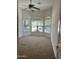 Bedroom with neutral carpet, ceiling fan, and three windows allowing natural light at 13542 W Port Au Prince Ln, Surprise, AZ 85379