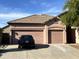 Home exterior showcases a three-car garage and desert landscaping in the front yard at 13542 W Port Au Prince Ln, Surprise, AZ 85379