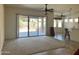 Bright living room with a large sliding glass door leading to the backyard, creating a seamless indoor-outdoor living experience at 13542 W Port Au Prince Ln, Surprise, AZ 85379