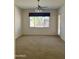 Bright living room with neutral carpet, ceiling fan, and a large window with natural light at 13542 W Port Au Prince Ln, Surprise, AZ 85379