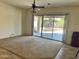 Spacious living room features a large sliding glass door with backyard view and a ceiling fan at 13542 W Port Au Prince Ln, Surprise, AZ 85379