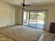 Bright living room features a large sliding glass door with backyard access and a ceiling fan at 13542 W Port Au Prince Ln, Surprise, AZ 85379