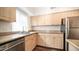 Well-lit kitchen featuring wooden cabinets, stone countertops, stainless steel appliances and undermount sink at 1411 E Orangewood Ave # 123, Phoenix, AZ 85020