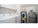 Interior laundry area with washer, dryer, water heater, water softener, and shelving at 1411 E Orangewood Ave # 123, Phoenix, AZ 85020