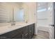 Bathroom featuring double sink vanity with framed mirrors and a separate tub/shower room at 15005 W Gray Fox Trl, Surprise, AZ 85387