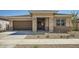 Inviting single-story home showcasing a neutral palette, stone accents, and a well-maintained front yard at 15005 W Gray Fox Trl, Surprise, AZ 85387
