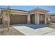 Charming single-level home features a spacious driveway, neutral-colored stucco, and stone-accented entryway pillars at 15005 W Gray Fox Trl, Surprise, AZ 85387