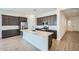 Modern kitchen features dark wood cabinets, stainless steel appliances, a large island, and stylish tile flooring at 15005 W Gray Fox Trl, Surprise, AZ 85387