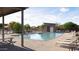 Community swimming pool with lounge chairs, nearby covered seating and changing room, landscaped surroundings, and clear skies at 15005 W Gray Fox Trl, Surprise, AZ 85387