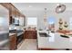 Modern kitchen featuring stainless steel appliances, granite countertops, a center island, and stylish pendant lighting at 15036 W Smoketree Dr, Surprise, AZ 85387