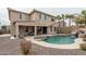 Spacious backyard with a sparkling pool, rock waterfall, and covered patio at 15658 W Cortez St, Surprise, AZ 85379