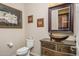 Charming powder room featuring a unique vanity, vessel sink, and ornate decor at 15658 W Cortez St, Surprise, AZ 85379