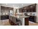 Spacious kitchen with dark cabinets, an island with seating, and modern appliances at 15658 W Cortez St, Surprise, AZ 85379
