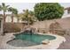 Beautiful backyard featuring a sparkling pool with a rock waterfall and lush landscaping at 15658 W Cortez St, Surprise, AZ 85379