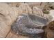 Detail of a tiled rock waterfall feature flowing into a sparkling swimming pool at 15658 W Cortez St, Surprise, AZ 85379