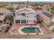 Aerial view of a backyard featuring a swimming pool, covered patio, outdoor kitchen, and desert landscaping at 16533 W Carmen Dr, Surprise, AZ 85388