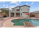 A backyard view featuring a swimming pool, a covered patio, an outdoor seating area, and a grill at 16533 W Carmen Dr, Surprise, AZ 85388