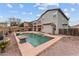 Backyard featuring a private pool, desert landscaping, and an outdoor dining area with market lights at 16533 W Carmen Dr, Surprise, AZ 85388